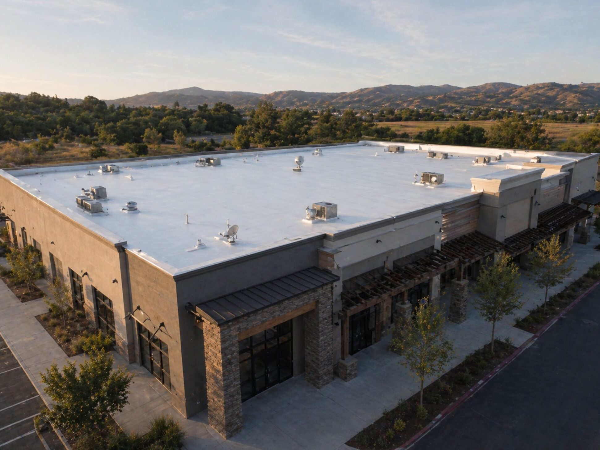 Commercial flat roof with white silicone coating system on low-slope building in Southern California