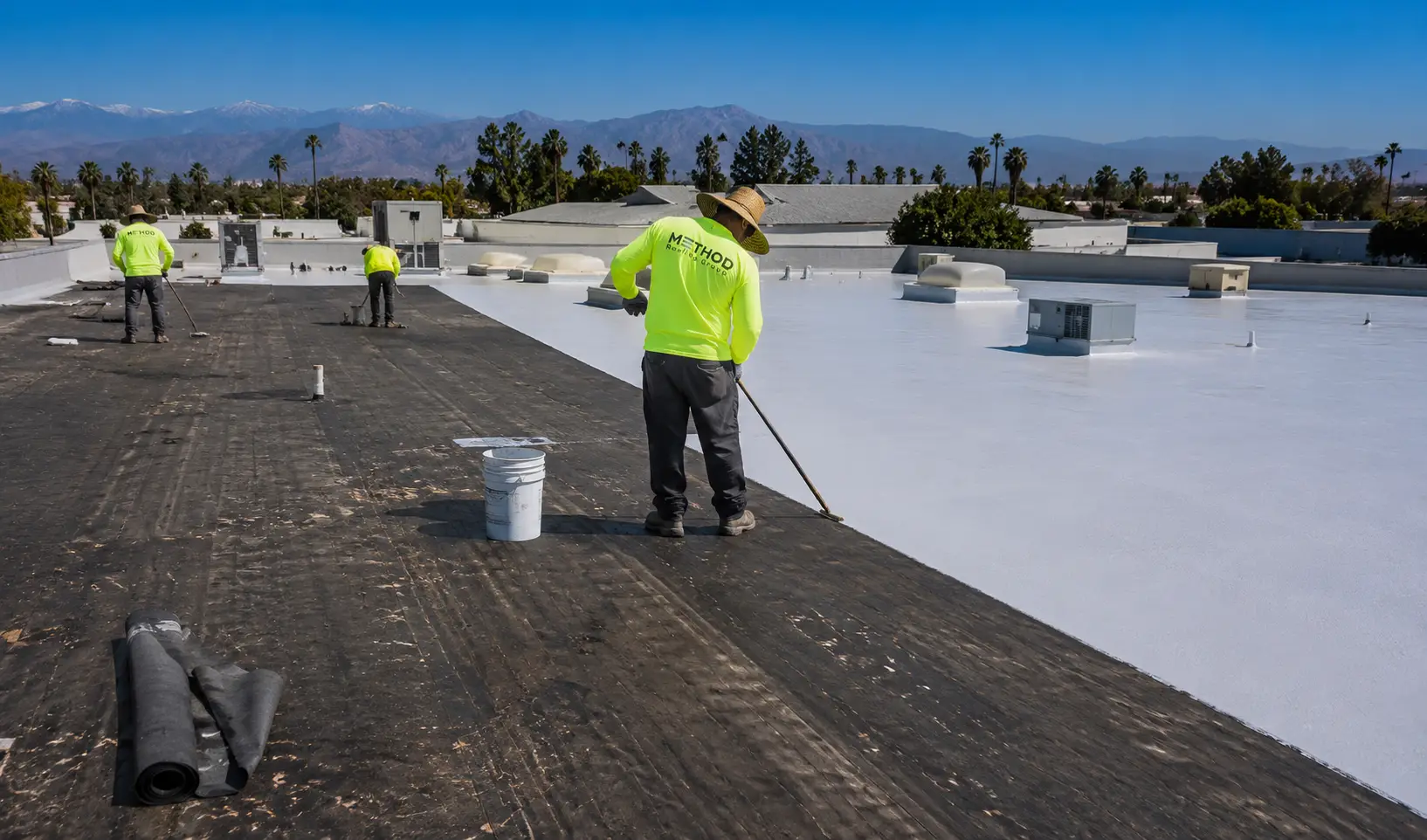 Method Roofing Group crew applying reflective white roof coating to a commercial flat roof in Southern California
