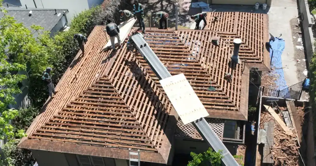 Aerial view of a residential roof replacement project in Orange County, California, showing an existing roof tear-off and exposed roof decking prior to new roof installation.